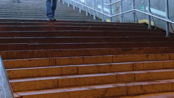 Folk går ned de våte trappene på en regnfull dag – stockvideo