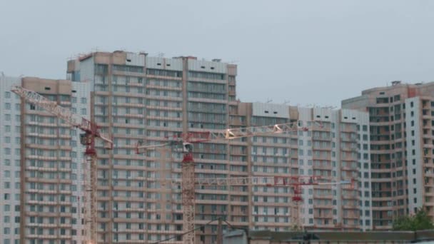 Lejligheder lejligheder lejligheder i en bygning under opførelse kraner nyt hus – Stock-video