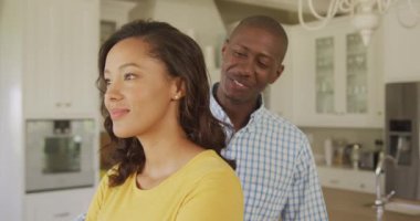 Afrika kökenli Amerikalı bir çift mutfakta birlikte vakit geçiriyorlar, sarılıyorlar, birbirlerine bakıyorlar ve gülümsüyorlar..