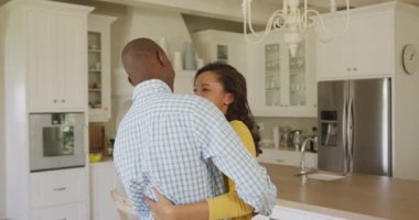 Afrika kökenli Amerikalı bir çift mutfakta dans ediyor, birbirlerine bakıyor ve gülümsüyor, ağır çekimde..