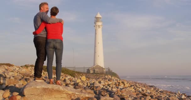 Caucasian Couple Enjoying Free Time Sea Sunset Embracing Lighthouse Slowmotion — Stock Video
