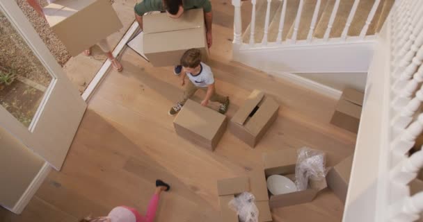 一对白种人迷人的夫妇 他们的女儿和儿子搬进新房子 走到门口 拎着纸板箱 慢吞吞地把它们放在地上 — 图库视频影像
