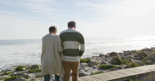 白人のカップルは ゆっくりとした動きで 晴れた日に海で自由な時間を楽しんでいます 海岸沿いの早期退職 — ストック動画