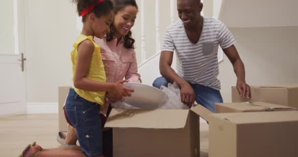 African American Couple Daughter Moving New House Kneeling Unpacking Box — Stock Video