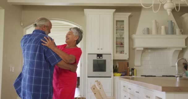 アフリカ系アメリカ人の高齢者のカップルが一緒に家で時間を過ごし キッチンで踊り お互いを見て笑顔で スローモーションで — ストック動画
