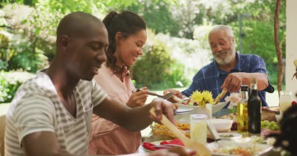Afroamerykanin Spędzający Czas Ogrodzie Siedzący Przy Stole Rodziną Kładący Jedzenie — Wideo stockowe