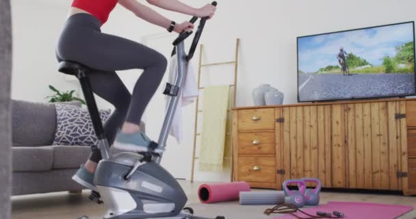 Mujer Caucásica Pasando Tiempo Casa Sala Estar Haciendo Ejercicio Bicicleta — Vídeos de Stock