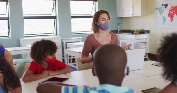 Kaukasiske Kvindelige Lærer Iført Ansigtsmaske Skolen Undervise Børn Skolen Klasseværelse – Stock-video