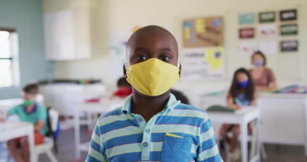 男の子の顔のマスクを着て カメラを見ての肖像画 Covi19コロナウイルスパンデミックの際の学校の安全性への教育 — ストック動画