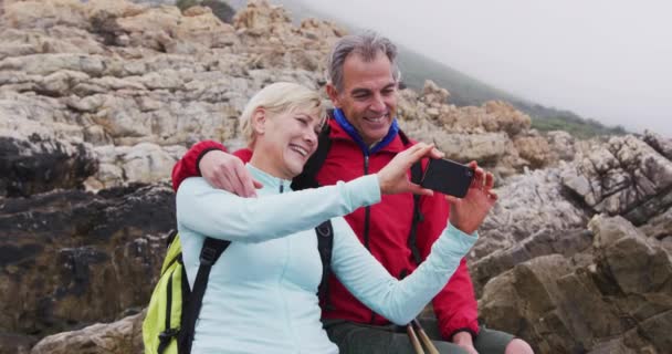 Sırt Çantalı Yaşlı Çift Kayalıklarda Oturuyor Deniz Kıyısında Yürüyüş Yaparken — Stok video