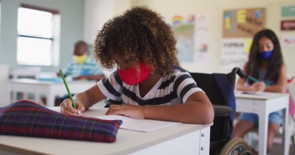 顔のマスクを身に着けている学校の子供たちの複数の民族グループ Covi19コロナウイルスパンデミックの際の学校の安全性への教育 — ストック動画