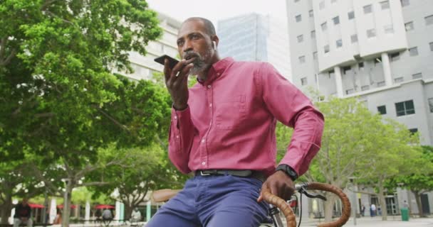 Uomo Affari Afroamericano Appoggiato Una Bicicletta Che Usa Uno Smartphone — Video Stock