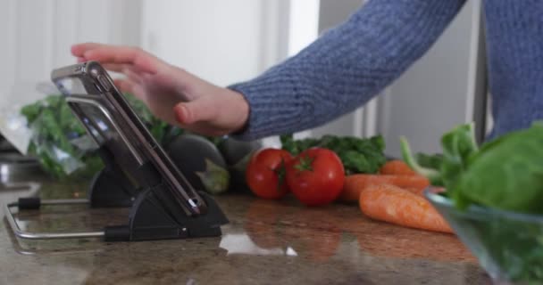 여성은 집에서 시간을 보내고 부엌에서 야채를 그녀의 디지털 태블릿을 동작으로 — 비디오