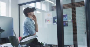 Kafkas erkek iş yaratıcısı, modern ofis Waring VR kulaklığı ile ağır çekimde etrafa bakıyor. Yaratıcı iş modern ofis.