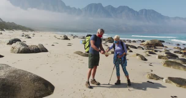 Coppia Escursionisti Anziani Indossano Maschere Facciali Con Zaini Bastoni Trekking — Video Stock