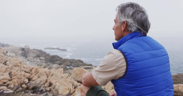 Senior Wandelaar Zit Rotsen Bergen Kijkt Naar Kust Trekking Wandelen — Stockvideo