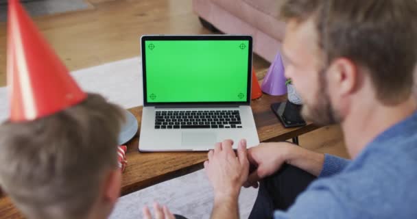 白人男人和他的儿子在一起 坐在沙发上 用笔记本电脑庆祝儿子的生日 食环动物检疫期间的社会疏离 — 图库视频影像
