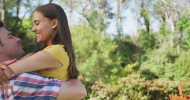 Bahçede mutlu beyaz bir çift, kadın taşıyan bir adam, güneşli bir günde kucaklaşıp gülümsüyor. Koronavirüs hücre hapsi sırasında bahçede vakit geçirmenin keyfini çıkarıyorum..