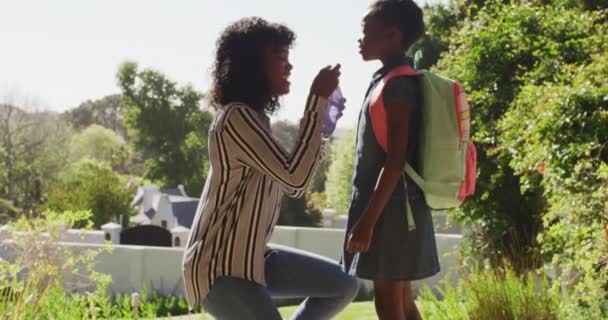 Afroamerikanische Mutter Setzt Tochter Mit Rucksack Einem Sonnigen Tag Freien — Stockvideo