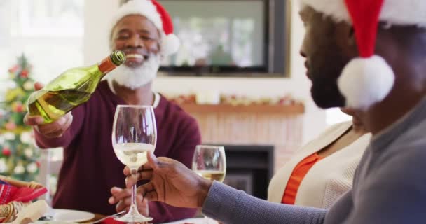 Pria Senior Afrika Amerika Dengan Topi Santa Menuangkan Minuman Dalam — Stok Video