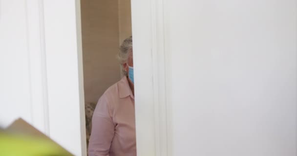 Casal Caucasiano Sênior Usando Máscaras Faciais Abrindo Porta Frente Para — Vídeo de Stock