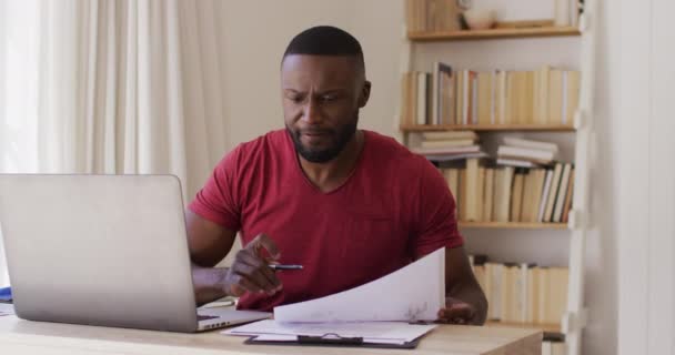 Przemyślany Afrykański Amerykanin Czytający Dokumenty Wyglądający Przez Okno Korzystający Laptopa — Wideo stockowe
