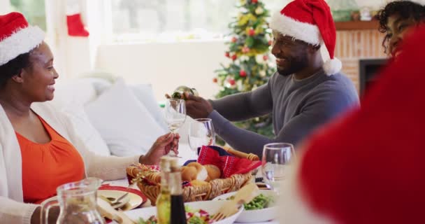 Afrikanisch Amerikanischer Mann Mit Weihnachtsmannhut Der Glas Einer Seniorin Trinkt — Stockvideo