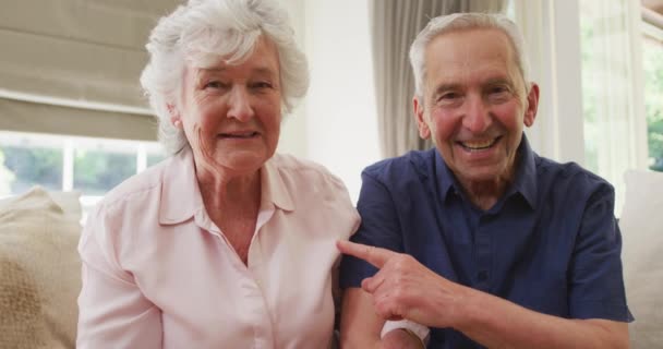 Kameraya Gülümseyen Sallayan Yaşlı Beyaz Bir Çiftin Portresi Oturma Odasında — Stok video
