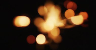 Odak dışı parti maytapları siyah arka planda parlıyor. Yılbaşı partisi şenlik kutlaması konsepti dijital olarak oluşturuldu.