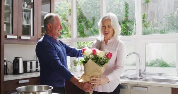 Senior Man Geeft Een Boeket Bloemen Aan Zijn Vrouw Knuffelt — Stockvideo