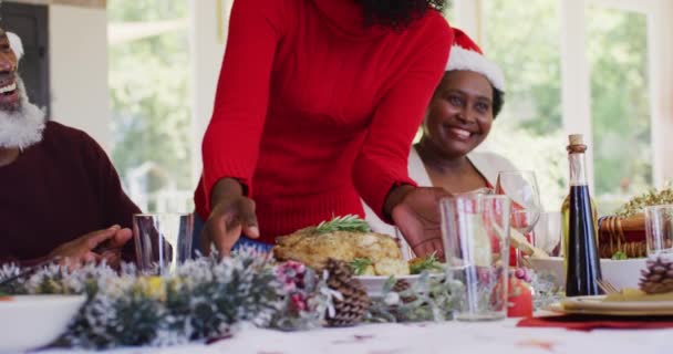 Eine Afroamerikanische Familie Mit Weihnachtsmützen Mutter Serviert Familie Esstisch Bevor — Stockvideo