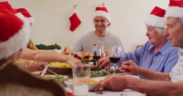 Kaukázusi Család Télapó Sapkában Ebédlőasztalon Élvezzük Ebédet Karácsonykor Otthon Karácsonyi — Stock videók