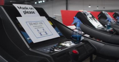 Spor salonundaki kullanım dışı makine tabelaları. Egzersiz makinesindeki güvenlik levhalarında sosyal mesafeyi ve maskeyi kullanmayın. Coronavirus covid 19 salgını sırasında spor salonunda hijyen.