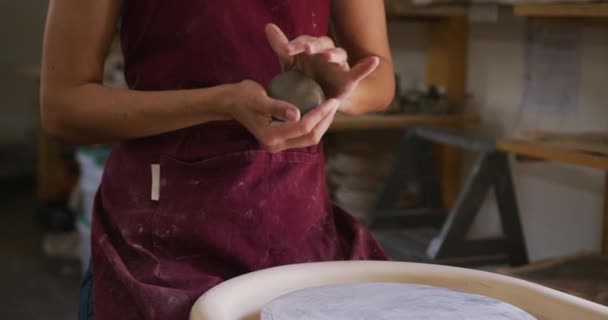 陶芸工房では 陶芸家の女性陶芸家がろくろで土の玉を保管しています コロナウイルスの間の陶芸スタジオの衛生と社会的距離は19のパンデミックを克服しました — ストック動画