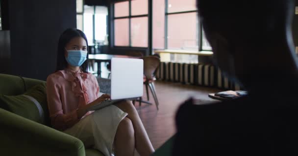 Mulher Asiática Usando Máscara Facial Usando Laptop Enquanto Senta Sofá — Vídeo de Stock