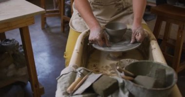 Çömlek atölyesinde çömlekçilik işini bitirmek için kadın çömlekçinin orta bölümünü kullanıyor. Coronavirus codemic 19 salgını sırasında çömlek atölyesinde hijyen ve sosyal mesafeler.