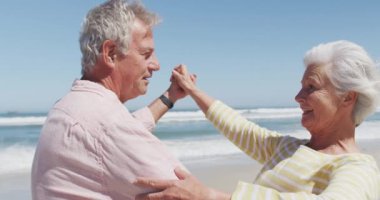 Kumsalda dans ederken birbirleriyle konuşan Kafkasyalı mutlu çift.