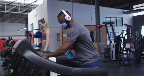 Fit Afrikanisch Amerikanischer Mann Mit Mundschutz Und Kopfhörer Der Fitnessstudio — Stockvideo