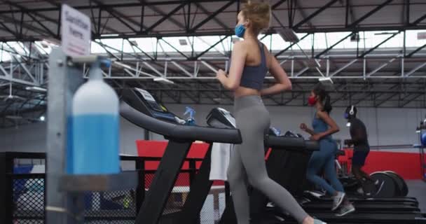 Beyaz Kadın Spor Salonunda Koşu Bandında Koşan Yüz Maskesi Takan — Stok video