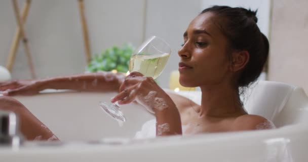 Donna di razza mista sdraiata in una vasca da bagno a casa — Video Stock