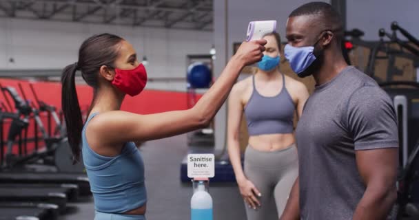 Fit Blanke Vrouw Dragen Gezichtsmasker Meten Temperatuur Van Fit Afro — Stockvideo