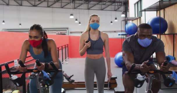 Spor Salonunda Maske Takan Beyaz Kadın Spor Eğitmeni Sabit Bisikletlerin — Stok video