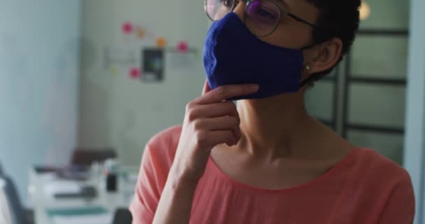 在现代的办公室里 一个头脑清醒的高加索女人戴着面罩 双手托着下巴 大肠癌大流行期间工作场所的卫生和社会疏离D — 图库视频影像