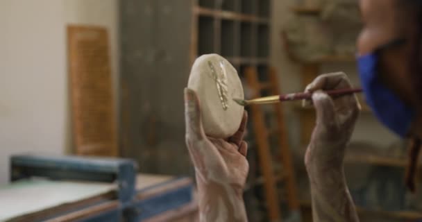 Kobieta Garncarz Noszenia Maski Twarzy Fartuch Pomocą Pędzla Malowania Ceramice — Wideo stockowe