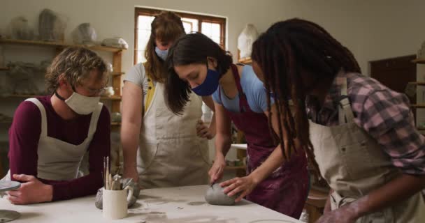 不同的陶工戴着面具和围裙在陶瓷厂做陶艺工作 大肠病毒大流行期间陶器工作室的卫生与社会疏离D — 图库视频影像