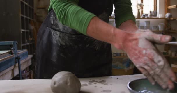 中段男性陶工在陶器工作室用围裙擦拭他的双手 大肠病毒大流行期间陶器工作室的卫生与社会疏离D — 图库视频影像