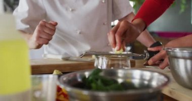 Çeşitli gruplara ders veren beyaz kadın şef. Yemek hazırlamak ve gülümsemek. Profesyonel bir mutfakta çalışıyorum..