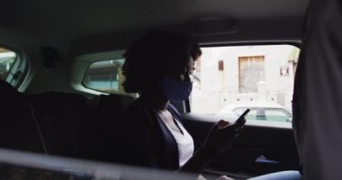 Arabada yüz maskesi takan Afrikalı Amerikalı kadın.