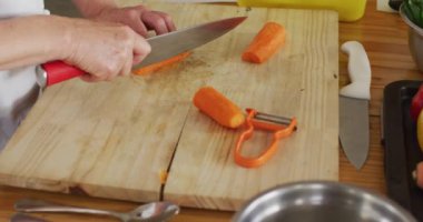 Kafkas kadın şef mutfakta havuç kesiyor. Coronavirus covid 19 salgını sırasında profesyonel bir mutfakta sağlık ve hijyen..