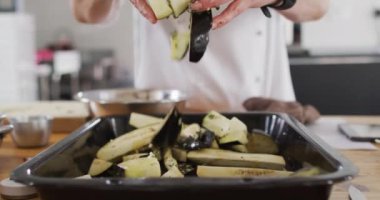 Beyaz kadın şef farklı gruplara yüz maskeleri takarak ders veriyor. Coronavirus covid 19 salgını sırasında profesyonel bir mutfakta sağlık ve hijyen..